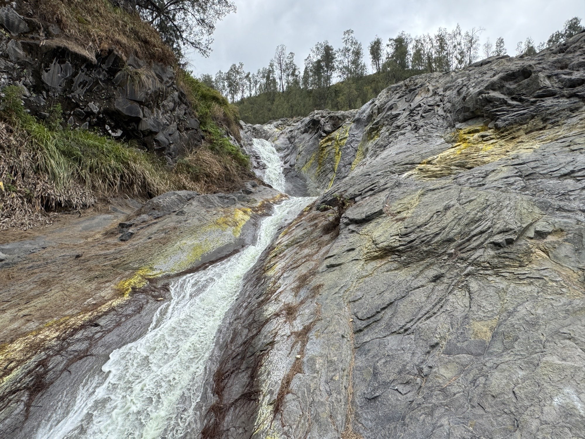 Waterfall cutting through exposed bedrock